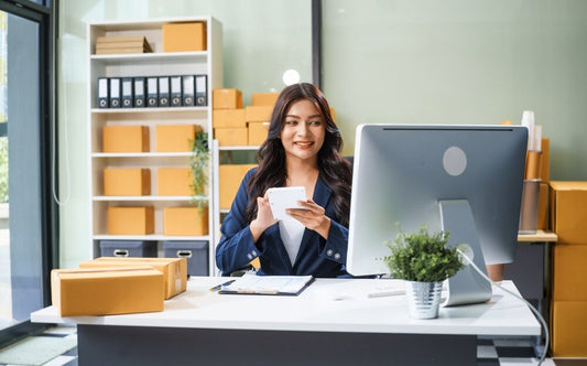 A young businesswoman sitting at her desk, viewing virtual address options on her computer screen.