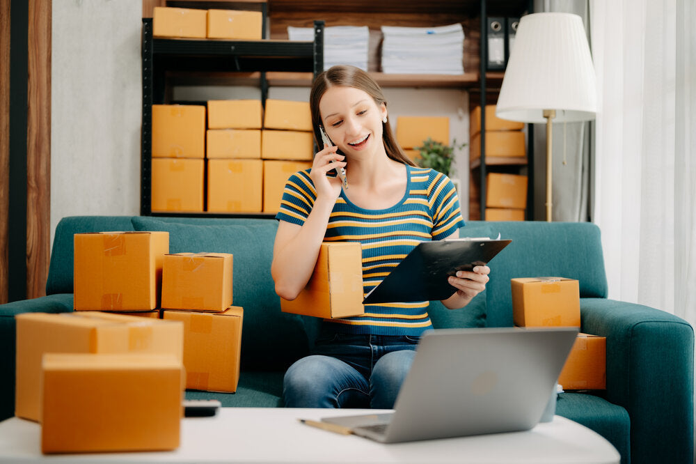 Lady packing multiple boxes – UK virtual address for Amazon sellers logistics and fulfilment