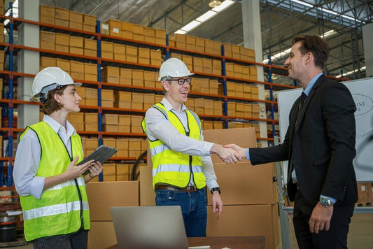 Warehouse address manager shaking hands with staff member at a trading estate, symbolizing trust and real business presence.