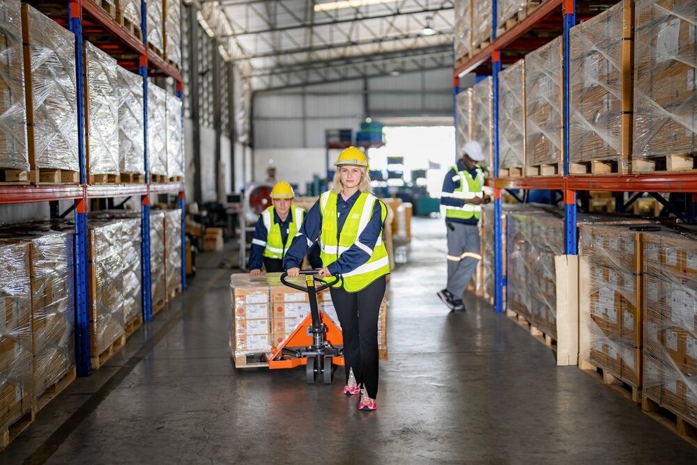 Worker Pulling Cardboard Boxes At Warehouse Address